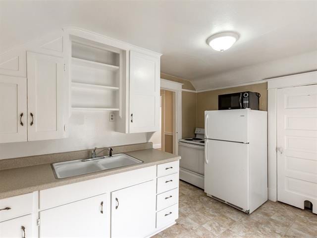 kitchen featuring light countertops, white appliances, a sink, and white cabinets