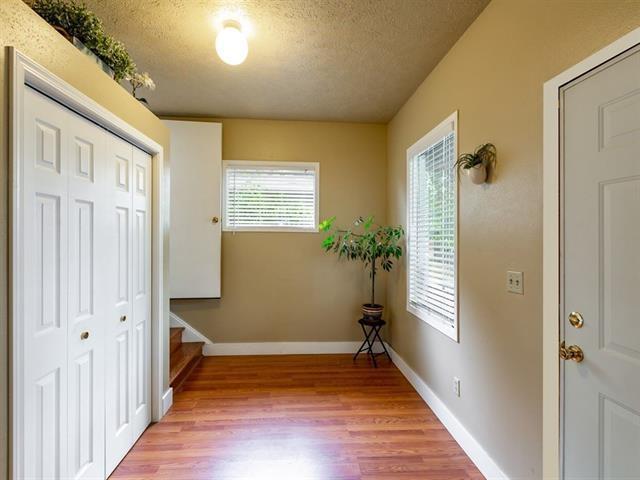 interior space featuring stairway, light wood-style flooring, baseboards, and a textured ceiling