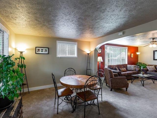 dining space featuring arched walkways, baseboards, plenty of natural light, and carpet