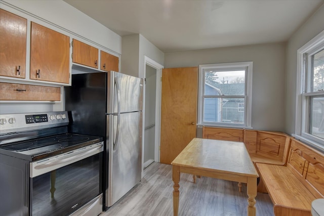 kitchen featuring brown cabinets, light wood finished floors, and stainless steel electric stove