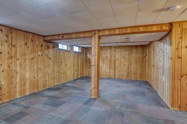 below grade area with wooden walls and carpet flooring