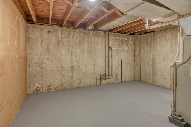 unfinished basement featuring heating unit