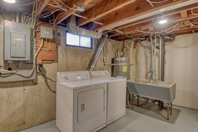 laundry room featuring laundry area, electric panel, washer and clothes dryer, water heater, and a sink