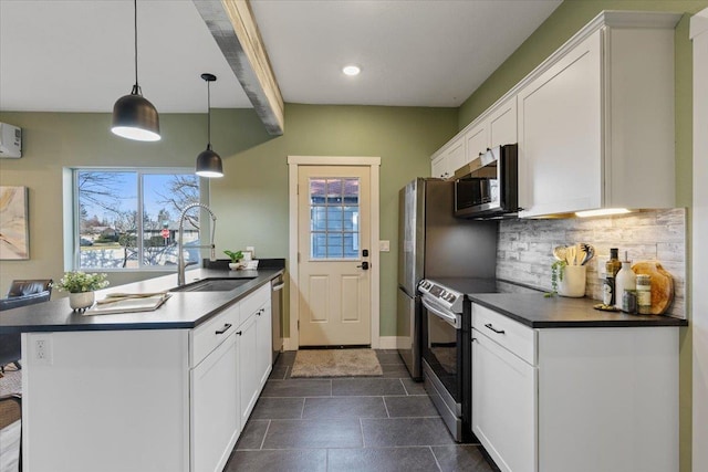 kitchen featuring dark countertops, a sink, stainless steel microwave, and electric range oven