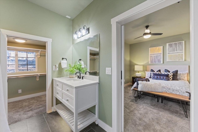ensuite bathroom with connected bathroom, a ceiling fan, vanity, baseboards, and tile patterned floors