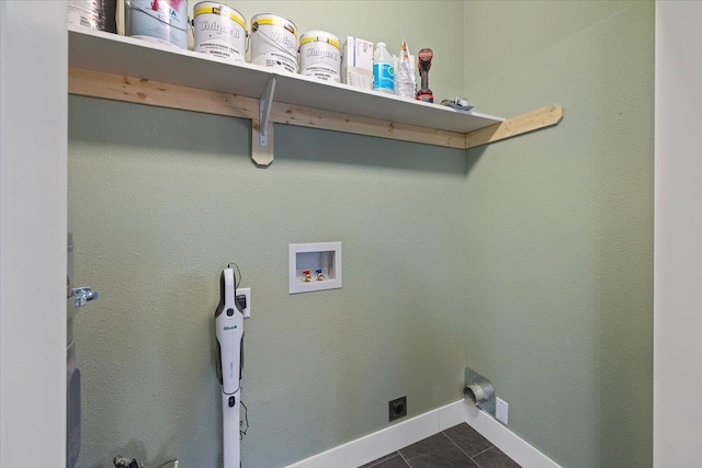 washroom featuring hookup for a washing machine, hookup for an electric dryer, laundry area, dark tile patterned flooring, and baseboards