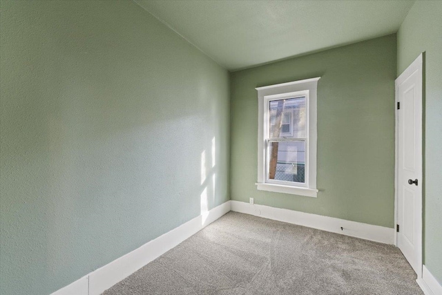 carpeted empty room with baseboards
