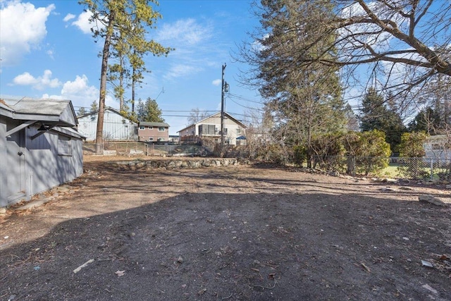 view of yard featuring fence and an outbuilding
