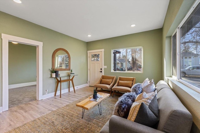 living area with baseboards, wood finished floors, and recessed lighting