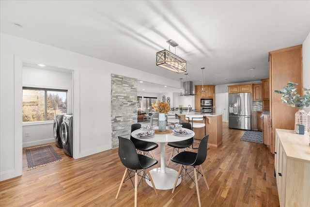 dining space featuring baseboards, recessed lighting, washing machine and dryer, and light wood-style floors