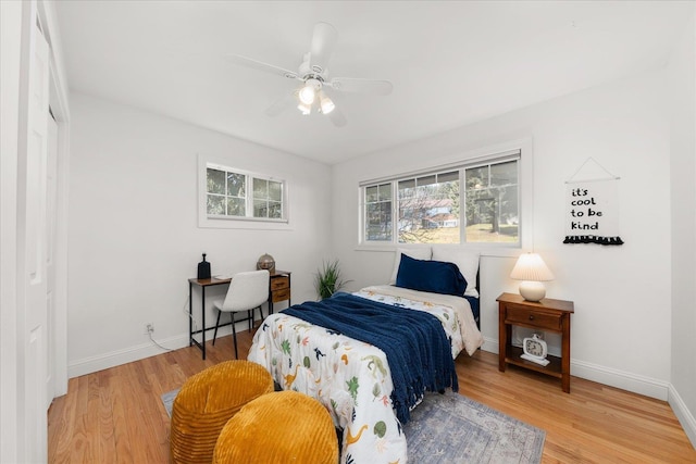 bedroom with ceiling fan, wood finished floors, and baseboards