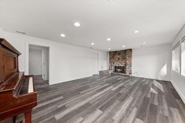 unfurnished living room featuring recessed lighting, a fireplace, baseboards, and wood finished floors