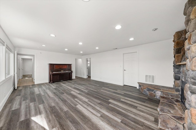 unfurnished living room featuring baseboards, wood finished floors, visible vents, and recessed lighting