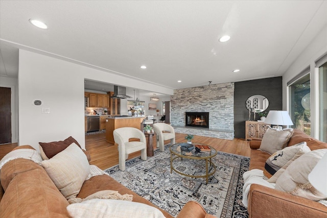 living area featuring a fireplace, light wood-style flooring, and recessed lighting