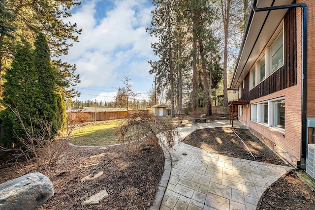 view of yard with a patio, an outdoor structure, and a fenced backyard