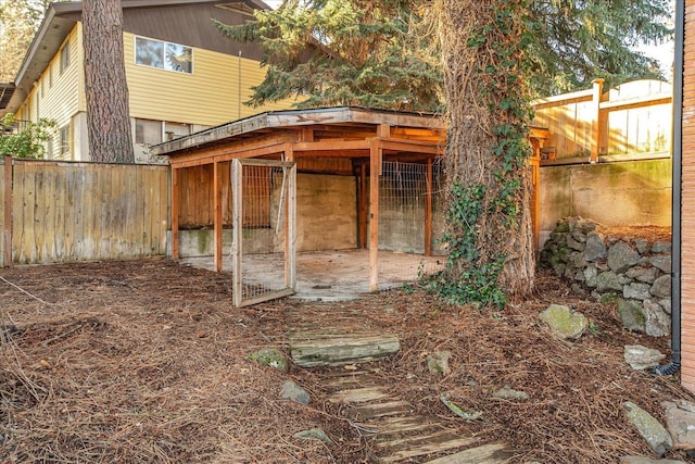 view of outdoor structure with a fenced backyard and an outbuilding