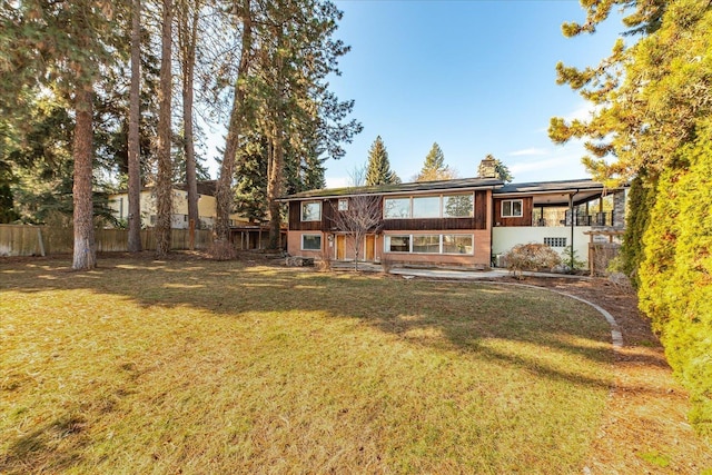 back of house featuring a yard and fence