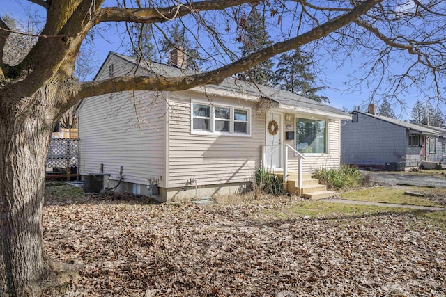 bungalow with a chimney and central air condition unit