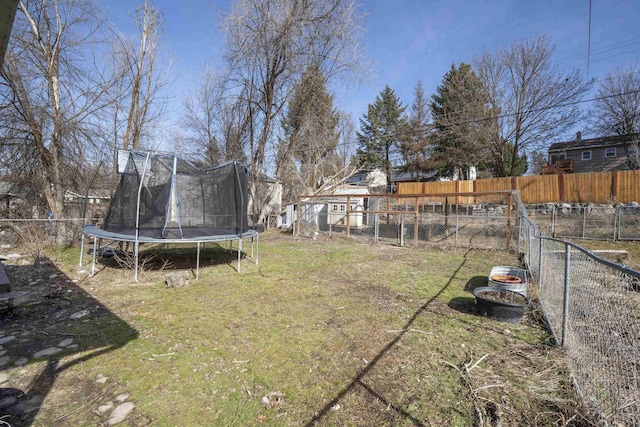 view of yard with a trampoline and a fenced backyard