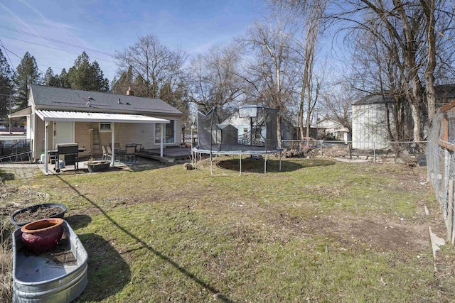 view of yard featuring a trampoline, a patio area, and a fenced backyard