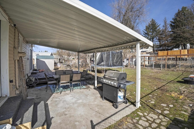 view of patio / terrace featuring outdoor dining area, a trampoline, area for grilling, and a fenced backyard