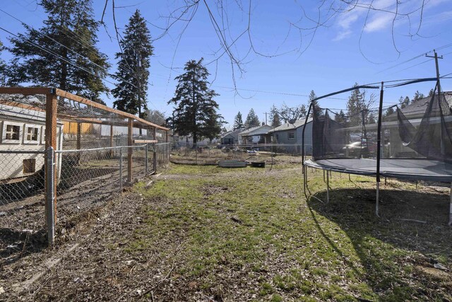 view of yard featuring a patio area, a fenced backyard, and a trampoline