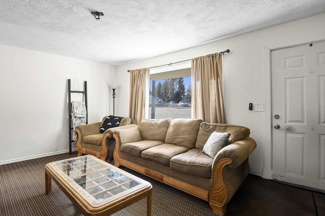 living room with baseboards, a textured ceiling, and carpet