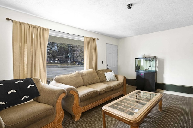 living area with a textured ceiling and baseboards