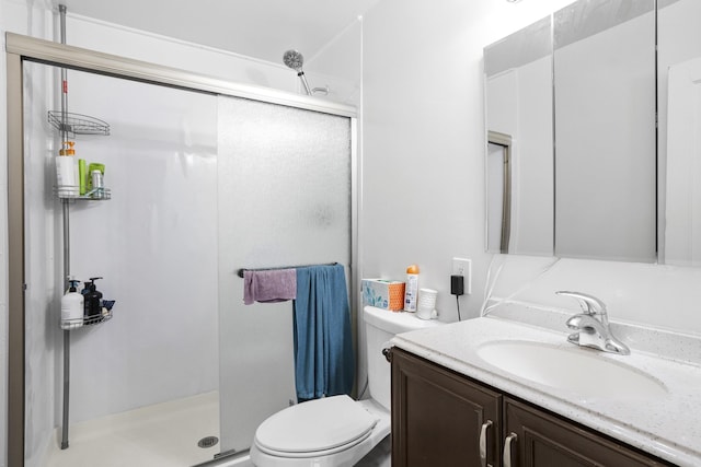 full bathroom with toilet, vanity, and a stall shower