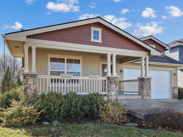 craftsman house featuring a garage, covered porch, stone siding, and concrete driveway