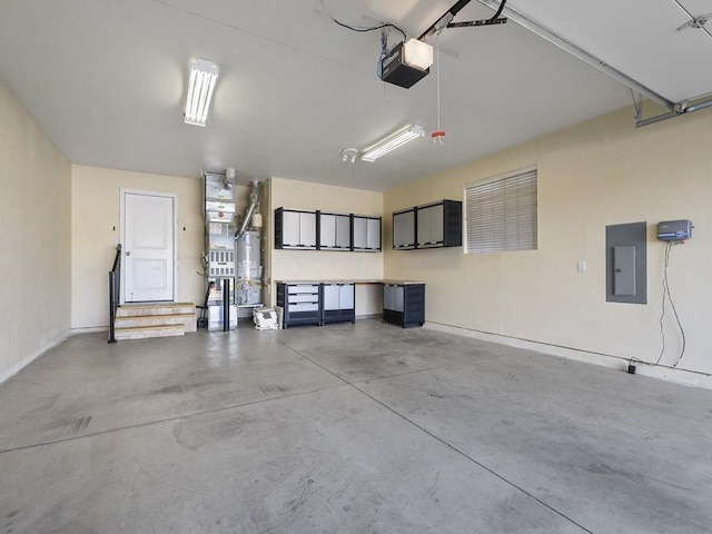 garage with secured water heater, electric panel, and a garage door opener