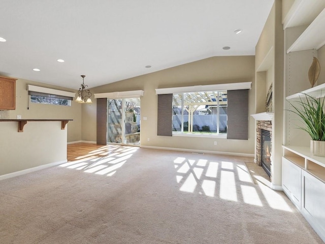 unfurnished living room featuring baseboards, light colored carpet, vaulted ceiling, a fireplace, and recessed lighting