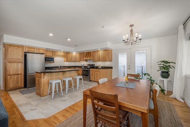 dining room featuring light wood-style floors, a chandelier, french doors, and recessed lighting