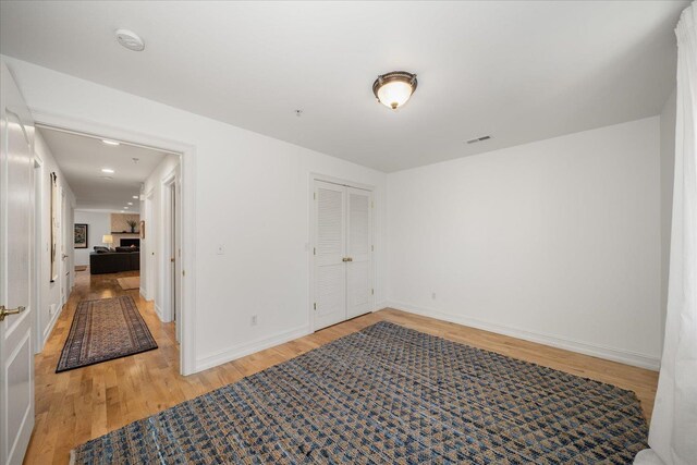 spare room featuring light wood-style floors, baseboards, and visible vents