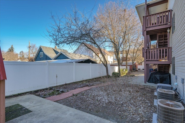 view of yard featuring fence private yard, cooling unit, a patio, and a balcony