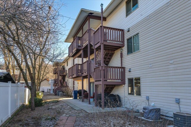 rear view of house with a patio, central air condition unit, fence, stairs, and a wooden deck