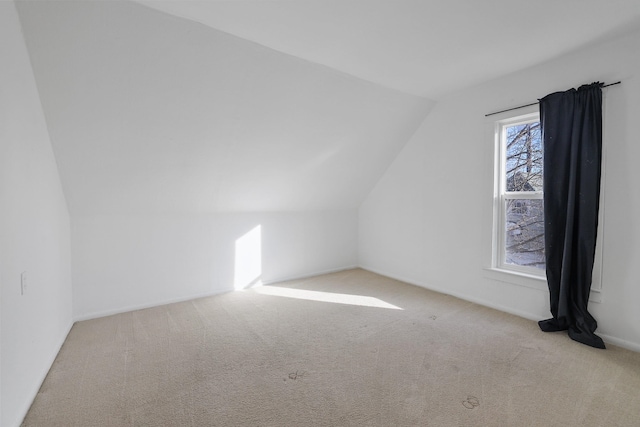 additional living space featuring lofted ceiling and carpet flooring