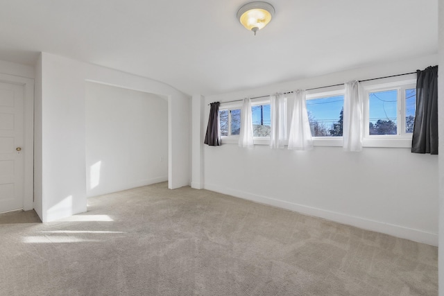 carpeted empty room with baseboards