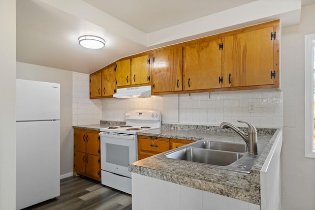 kitchen featuring white appliances, brown cabinets, a sink, and under cabinet range hood