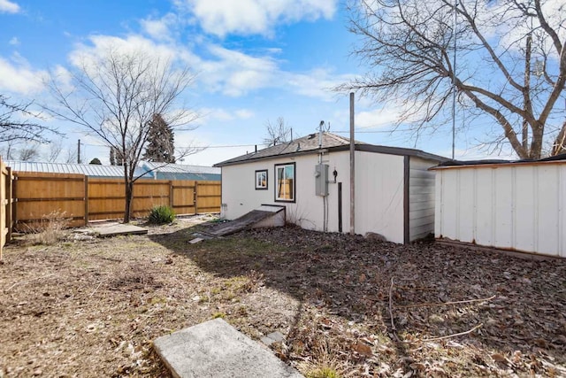 rear view of house with a fenced backyard