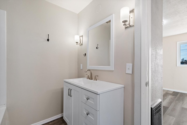 bathroom featuring vanity, baseboards, and wood finished floors