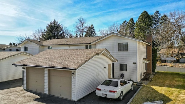 view of front of home featuring a shingled roof, a chimney, and a front yard