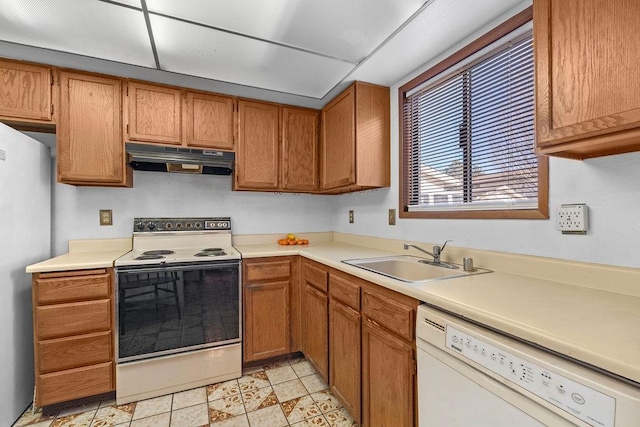 kitchen with electric stove, freestanding refrigerator, white dishwasher, a sink, and under cabinet range hood