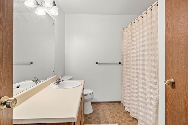 bathroom featuring curtained shower, vanity, and toilet