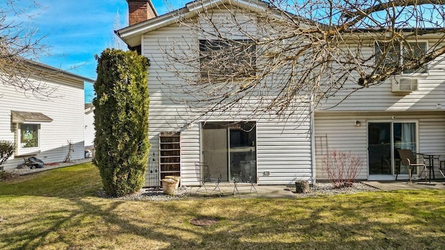 rear view of house featuring a yard and a chimney