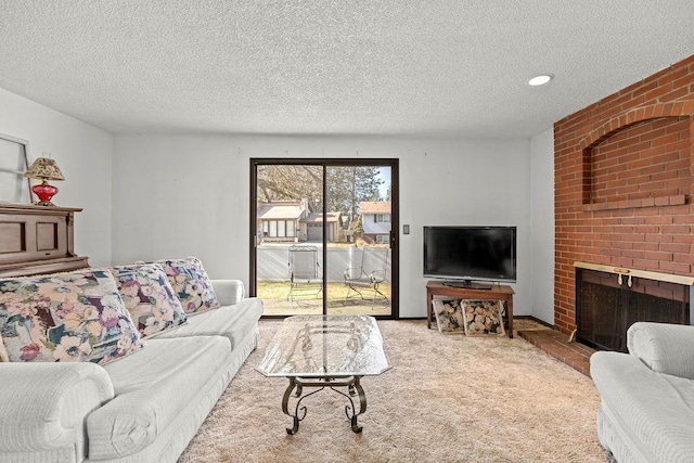 carpeted living area featuring a fireplace, a textured ceiling, and recessed lighting