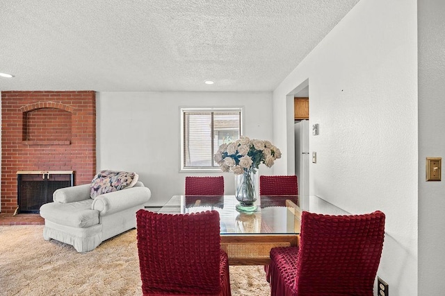 carpeted dining space with a textured ceiling and a fireplace