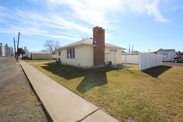 view of home's exterior featuring cooling unit, a yard, a chimney, and fence