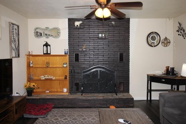 living room featuring a tile fireplace, ceiling fan, and wood finished floors