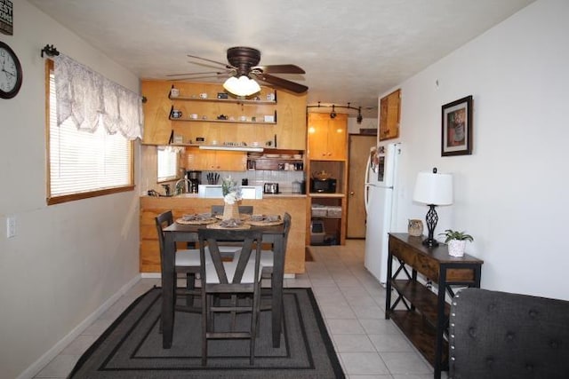 dining room with light tile patterned floors, ceiling fan, and baseboards